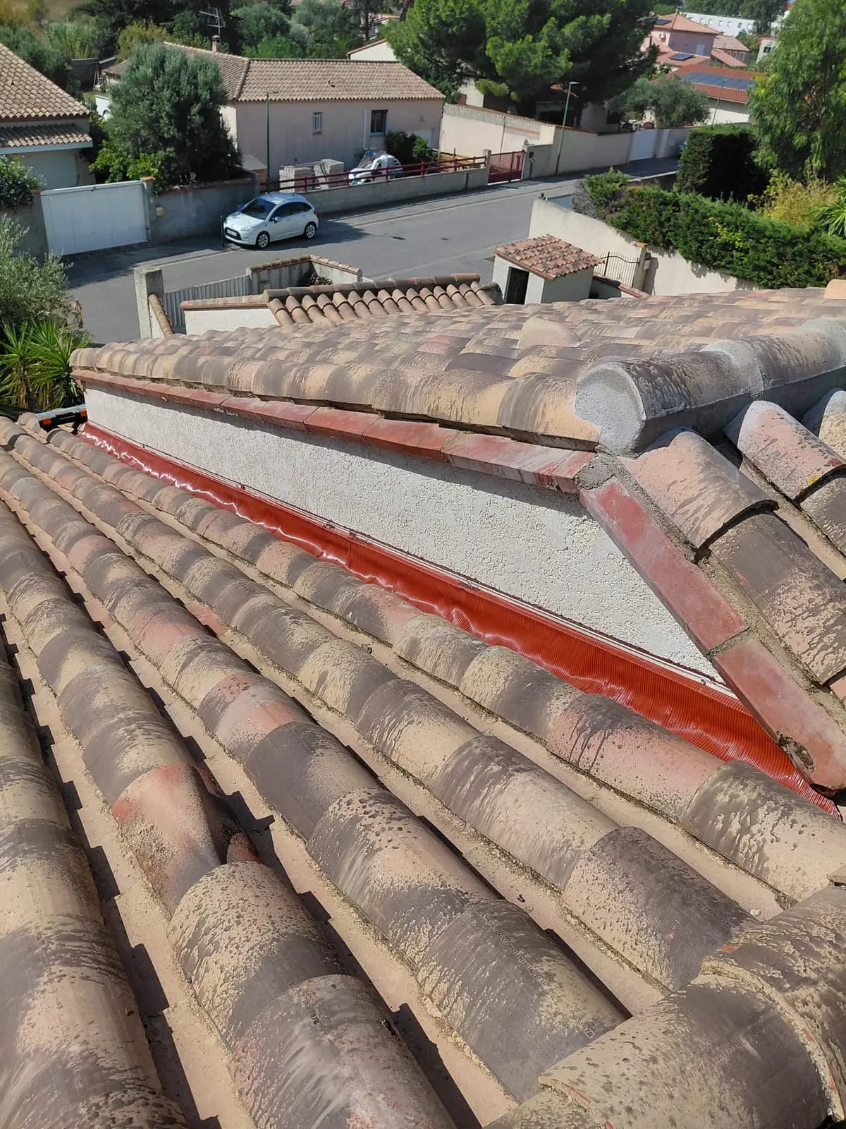 Solin en zinc laqué rouge posé en raccord de mur sur une couverture en tuile canal — HH Couverture